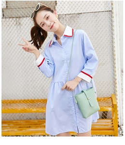 Detail of mint green textured faux leather crossbody bag with striped shirt dress