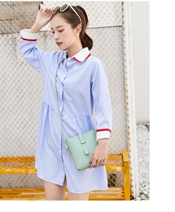 Detail of mint green crossbody bucket bag paired with a blue striped shirt dress