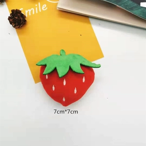 Detailed view of red plush strawberry accessory with 7x7cm size markings