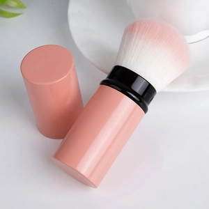 Detail der weichen rosa Farbverlaufsborsten und Staubschutzkappe eines Make-up-Pinsels