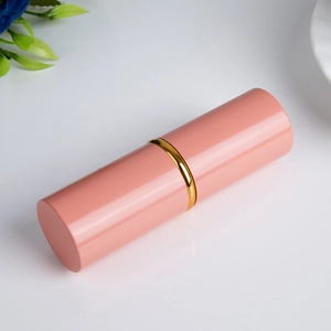 Detail eines rosa ausziehbaren Make-up-Pinsels mit goldenem Ring auf floralem Hintergrund