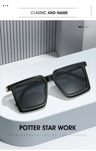 Detail of square black sunglasses showing the golden metal hinge and sleek polished frame