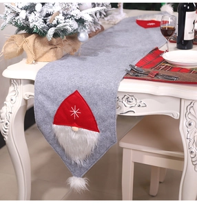 Detail of grey felt Christmas table runner featuring red gnome motifs and white snowflakes