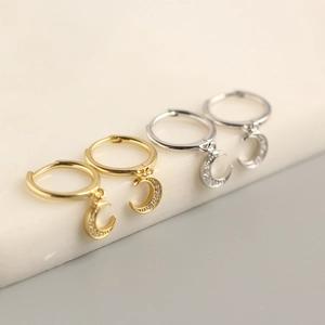 Macro detail of gold and silver S925 sterling silver crescent moon drop earrings with crystals