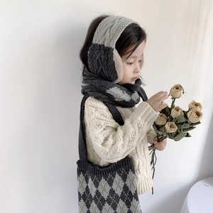 Kids knitted scarf and earmuff set featuring grey diamond patterns on a young model