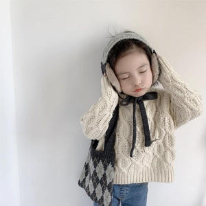 Detailed knit texture of children's grey earmuffs and beige scarf winter set