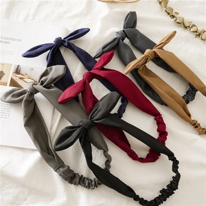 Flat lay of soft fabric knotted headbands in navy, gray, burgundy, and camel tones