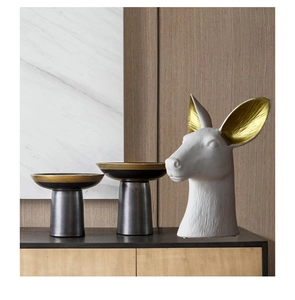 Detail of Nordic white deer head ceramic vase and elegant black gold decorative trays