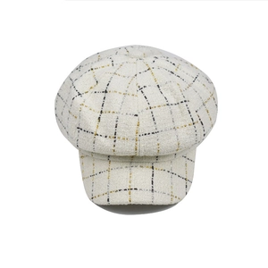 Vue de dessus d'une casquette gavroche en tweed blanc avec motifs à carreaux dorés