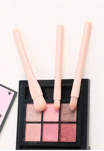 Detail of three soft pink eye brushes with fluffy synthetic bristles for blending eyeshadow