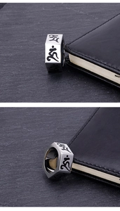 Macro detail of hexagonal titanium steel ring with engraved Sanskrit mantras on dark rock