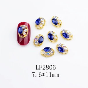 Close-up of LF2806 nail charms with blue rhinestones, pearls and gold twisted borders