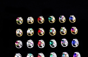 Detailed macro view of oval K9 crystal nail charms with twisted alloy borders and pearls