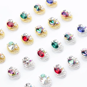 Close-up of assorted K9 alloy nail charms with colorful crystals and pearl accents