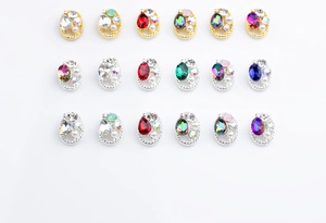 Macro view of oval alloy nail charms with colorful rhinestones and pearl borders