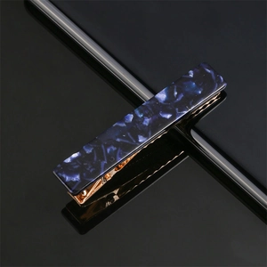 Detailed close-up of blue marble acrylic hair clip with a gold metallic base