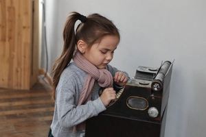 Close-up of a child wearing a warm pink ribbed knit scarf with a grey sweatshirt