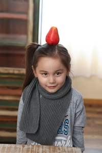 Detailed knit texture of grey children's winter scarf paired with long sleeve sweatshirt