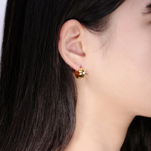 Polished gold stainless steel hoop earrings worn by a model for a minimalist look