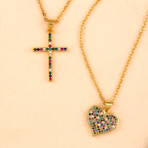 Detail of gold chain necklaces with cross and heart pendants featuring colorful cubic zirconia