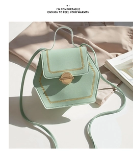 Detail of mint green crossbody bag with lychee texture and gold chain stitch edges