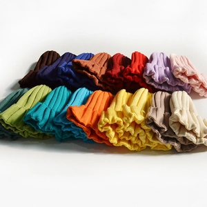 Minimalist knitted beanies in various solid colors shown in an organized overhead layout