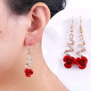 Detail of red rose drop earrings with spiral diamond accents and gold finish plating
