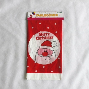 Gros plan d'une nappe de Noël jetable en plastique rouge avec imprimé Père Noël