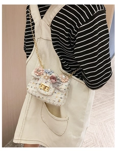 Dettaglio della mini borsa a tracolla in tweed con fiori su una modella bambina