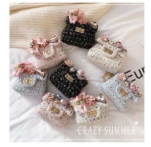 Dettaglio di mini borse in tweed con ciondoli a forma di coniglio e fiori di perle