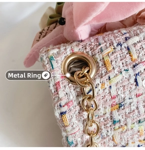 Dettaglio del tessuto in tweed rosa con anelli dorati e catena di una borsa per bimbi