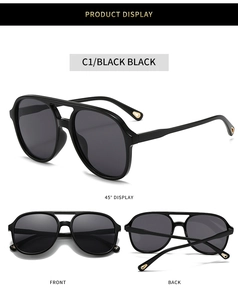 Detail view of black oval pilot sunglasses with reinforced double bridge and gold accents