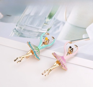 Dettaglio di spille ballerina in smalto rosa e verde pastello con placcatura in oro