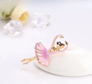 Dettaglio dell'elegante spilla ballerina dorata con gonna in smalto rosa e cristalli