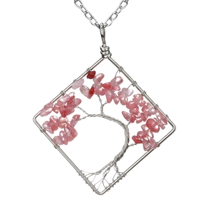 Macro view of handmade wire wrapped tree of life necklace with pink crystal stones