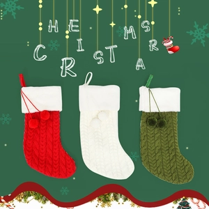 Détail de chaussettes de Noël en maille torsadée avec bordure peluche et pompons