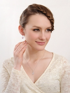 Close-up of elegant silver pendant necklace and purple floral earrings on a female model