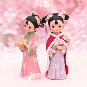 Detail of vintage Chinese court style resin figurines in pink and purple floral robes