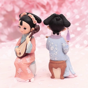 Close-up of vintage Chinese style princess dolls playing pipa and flute in pink cherry blossoms