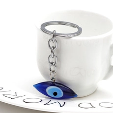 Detailed close-up of a blue evil eye bead on a metal keychain with polished ring link