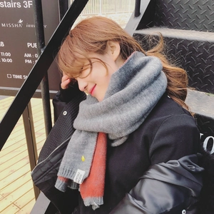 Gros plan sur une écharpe en maille épaisse avec patchwork rouge-gris et broderie ananas