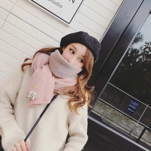 Détail de l'écharpe en maille rose et beige avec étiquette portée par un mannequin