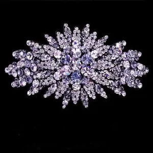 Detail of flower-shaped headband with purple and white crystals on black background