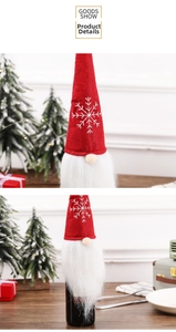 Close-up of Nordic gnome wine bottle cover with red felt hat and white snowflake embroidery