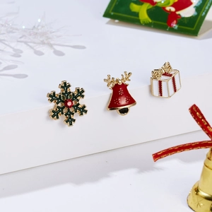 Detail of Christmas stud earrings with snowflake, reindeer and gift box on festive display