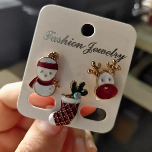 Detail of Christmas stud earrings set featuring enamel snowman, reindeer, and sock charms