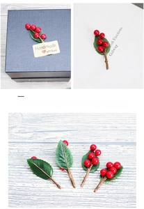 Dettaglio di bacche rosse e foglie verdi con stelo flessibile per scatole regalo