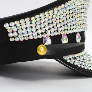 Detailed close-up of rainbow rhinestones and golden star buckle on black captain hat