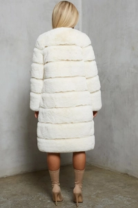 Detail of white long faux fur coat showing horizontal tiered panels and premium texture