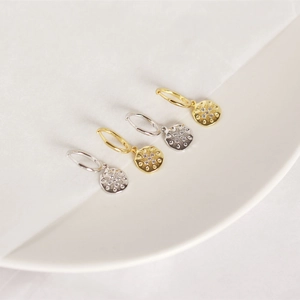 Detail of S925 sterling silver hoop earrings with sunburst star pendants and small crystals